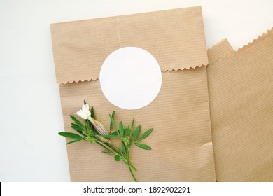 Round blank sticker mockup, circle tag mock up on kraft paper gift bag, adhesive round product label.