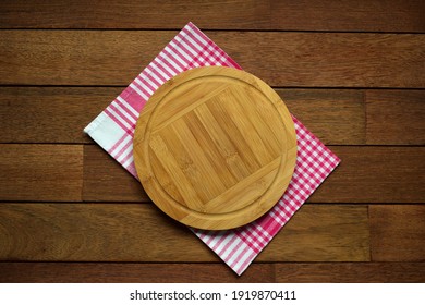 Round Board On Checkered, Red And White Napkin On Wooden Table, Top View 