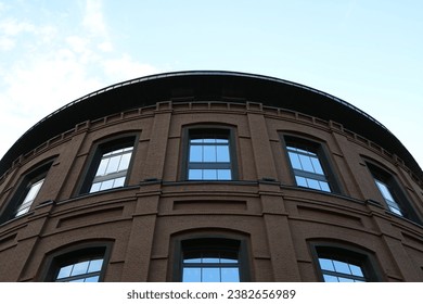 Round brick building with curved roof and large windows against blue sky
 - Powered by Shutterstock