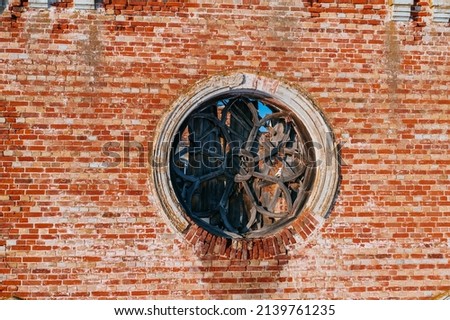 Round broken stained glass window in old abandoned church.