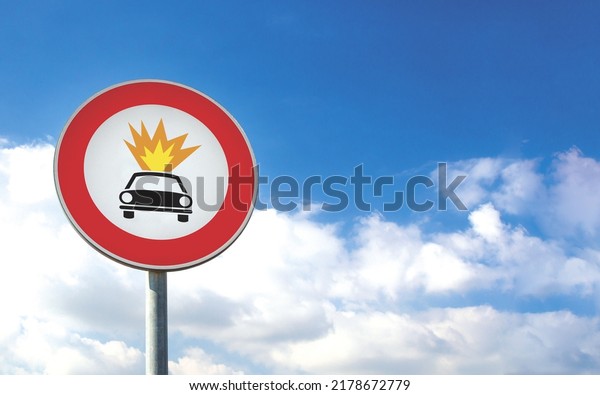 Round car sign transit prohibited for vehicles\
carrying explosive substances on a blue sky background. Car road\
sign, prohibition red\
sign.