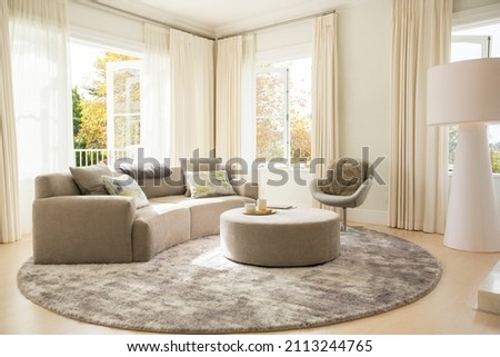 Round carpet under sofa and ottoman in living room