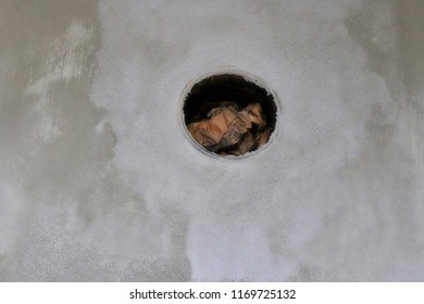 Round Chimney Hole In The Grey Wall Clogged With Old Newspaper