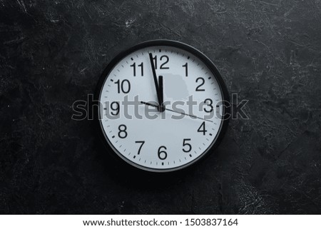 Round clock with numbers on old background.