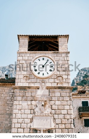 Round clock on an ancient stone clocktower. Kotor, Montenegro