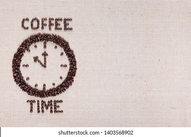 Round clock pointing eleventh hour along with coffee time words made of coffee beans on linen texture, aligned left