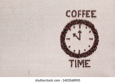 Round clock pointing eleventh hour along with coffee time words made of coffee beans on linen texture, aligned right