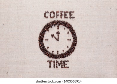 Round clock pointing eleventh hour along with coffee time words made of coffee beans on linen texture, aligned in center