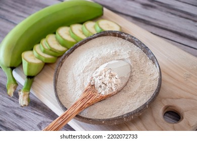 Round Coconut Plate With Banana Flour, Spoon And Raw Bananas On A Wooden Background. Starch Resistant, Prebiotic Foods, Gut Health, Keto, Ketogenic Diet, Low-carb Diet, Gluten Free, Plant Based Vegan