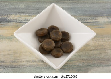 Round Cola Flavored Hard Candy In White Candy Dish On Table