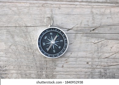 runder Kompass auf Naturhölzernem Hintergrund als Symbol für Tourismus mit Kompass, Reisen mit Kompass und Aktivitäten im Freien mit Kompass