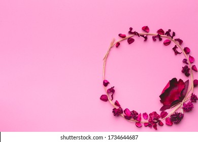 분홍색 종이 배경에 말린 꽃들의 둥근 구성. 풀과 말린 꽃의 화환. 플랫 레이, 공간 복사, 최상위 뷰 스톡 사진