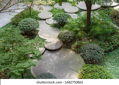 Round Concrete Steps In The Small Garden. Top View Of Pathway Between Bushes And Trees. Landscape Design Of Sustainable Green Architecture. Stepping Stones At Greenery.