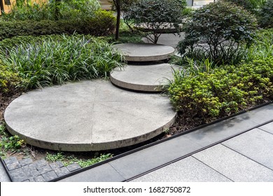 Round Concrete Steps in the Small Garden. Pathway Between Bushes and Trees. Landscape Design of Sustainable Green Architecture. Stepping Stones at Greenery. - Powered by Shutterstock