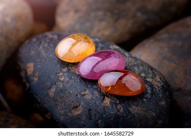 Round cut mineral gemstones with dark stones background.