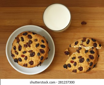 Round Delicious Cookies, Biscuits With Raisins Whole And Broken Down Into Two Parts And A Glass Of Natural Milk On Brown Wooden Background. Top View.