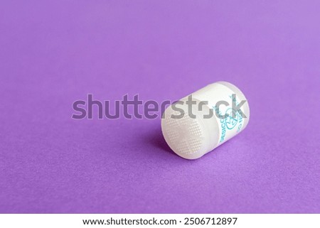 Round desiccant for drying various items on a purple surface. Macro shot, copy space.