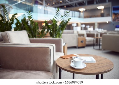 Round desk with business literature, cup of hot drink and wallet at airport waiting room stock photo - Shutterstock ID 1686994039