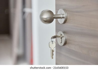 Round Doorknob On A Modern Apartment Door With A Key In The Lock