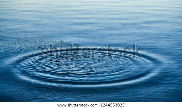 水の上の円の上に丸い水滴 水が落ち 渦 水が飛び散る 海のテクスチャパターン背景に波紋 デスクトップまたはノートパソコンの壁紙 ウォーターリングの接写はサーフェスに影響を与えます の写真素材 今すぐ編集