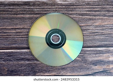 Round DVD compact disk object isolated on wooden table surface background.