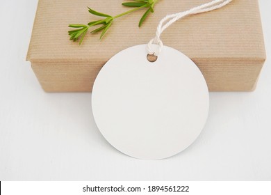 Round empty gift tag mock up, wedding favor, product tag mockup, blank paper label with string on gift box.	     - Shutterstock ID 1894561222