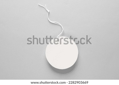 Round empty white price tag with string on gray background. Template for design