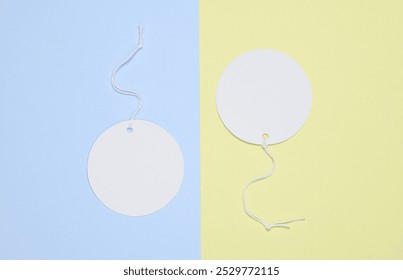 Round empty white price tags with string on yellow blue background. Template for design - Powered by Shutterstock