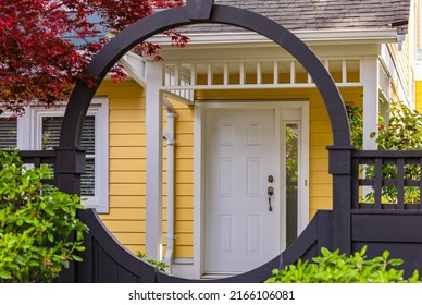 Round entrance gate. Entrance of a typical townhouse with a patio in Vancouver, Canada. Home exterior with patio area with nice landscaping desing around. Nobody, selective focus, street photo