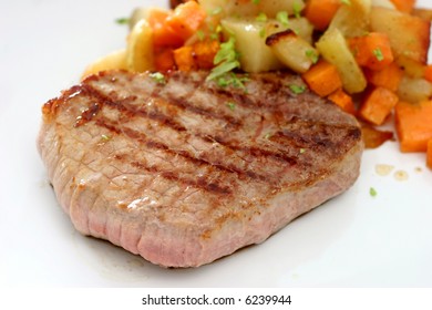 A Round Eye Steak Fried On A Grilling Pan With A Serving Of Mixed Cubed Vegetables