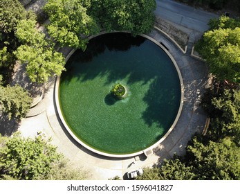 round fountain with green water in forest veiw from top down