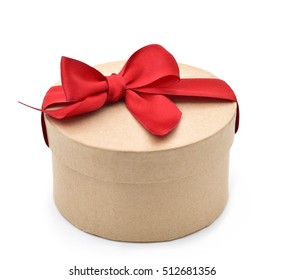 A Round Gift Box With A Red Ribbon Bow On A White Background 