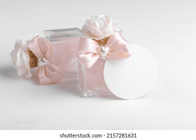 Round gift tag mockup with beige wedding favor on a white background, decorative bottle with favor tag mockup. Wedding favor tag for souvenir, sign for message greeting, close up, element for design - Shutterstock ID 2157281631