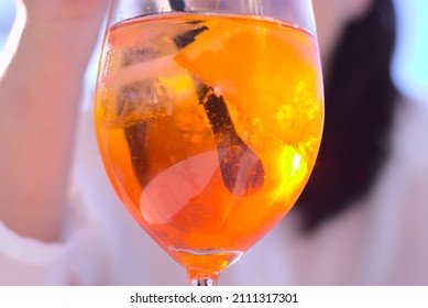 Round Glass With A Refresh Cocktail. Pretty Woman Background Out Of Focus. Bottom View Closeup. Vacation And Travel Concept. Party Event Celebration. Copy Space. High Quality Photo