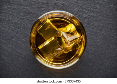 Round Glass Of Whiskey With Ice On A Black Background Shot From Above