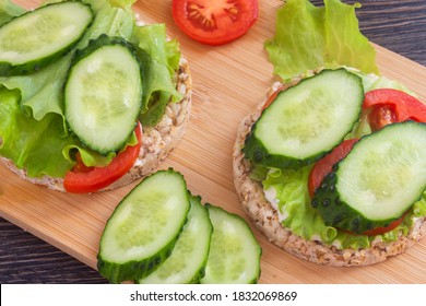 Round Grain Bread With Fresh Vegetables. Green Salad, Pepper, Tomato, Cucumber. Diet Wholegrain Cracker On A Wooden Board. Breakfast Concept For Dieters, Vegans, Proper Nutrition. Top View. Flat Lay.