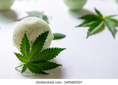 Round green cannabis bath bombs with marijuana leaves isolated on white background