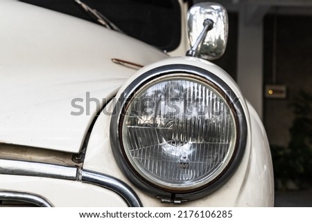 Round headlight of a white old timer car. Close up photo with soft selective focus