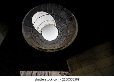 A Round Hole In The Ceiling Of An Abandoned, Concrete Building