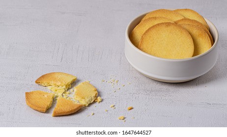 Round Homemade Cookies In A Bowl On A Grey Background. One Cookie Crashed On A Left Side 