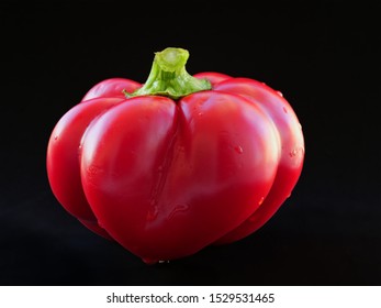 Round of Hungary sweet pepper, specialty pimento cheese is a ribbed, flattened pepper of intense red with very thick, sweet, delicious flesh.Whole paprika pepper over dark background.