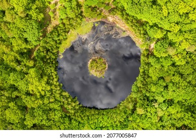 Round Lake With Island In The Middle Among Forest, Aerial View