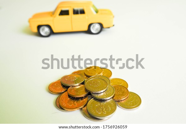 round metal coins of Polish yellow and gray are\
strewn on a light table against the background of a yellow small\
car .  metal money poland