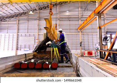 Round Metal Steel Discharging From The Electric Crane Hook Onto The Lorry Trailer  By Truck Driver.