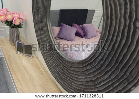 Round mirror in the interior of a modern bedroom