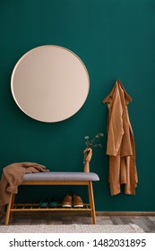 Round mirror on green wall in stylish hallway interior