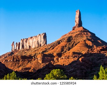 Round Mountain in the Castle Valley near Moab, Utah with Castleton Tower (Castle Rock) and the Priest and Nuns rock formation with deep blue sky - Shutterstock ID 125585924