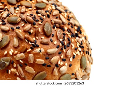 Round multigrain bread roll covered with pumpkin seeds, sunflower seeds, sesame, and black sesame.