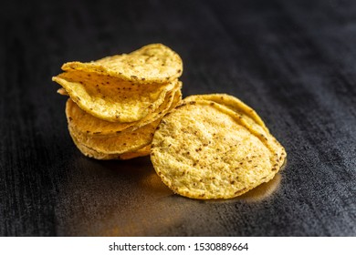 Round Nacho Chips. Yellow Tortilla Chips On Black Table.