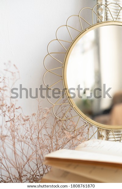 A round old mirror with a delicate frame stands on\
the table